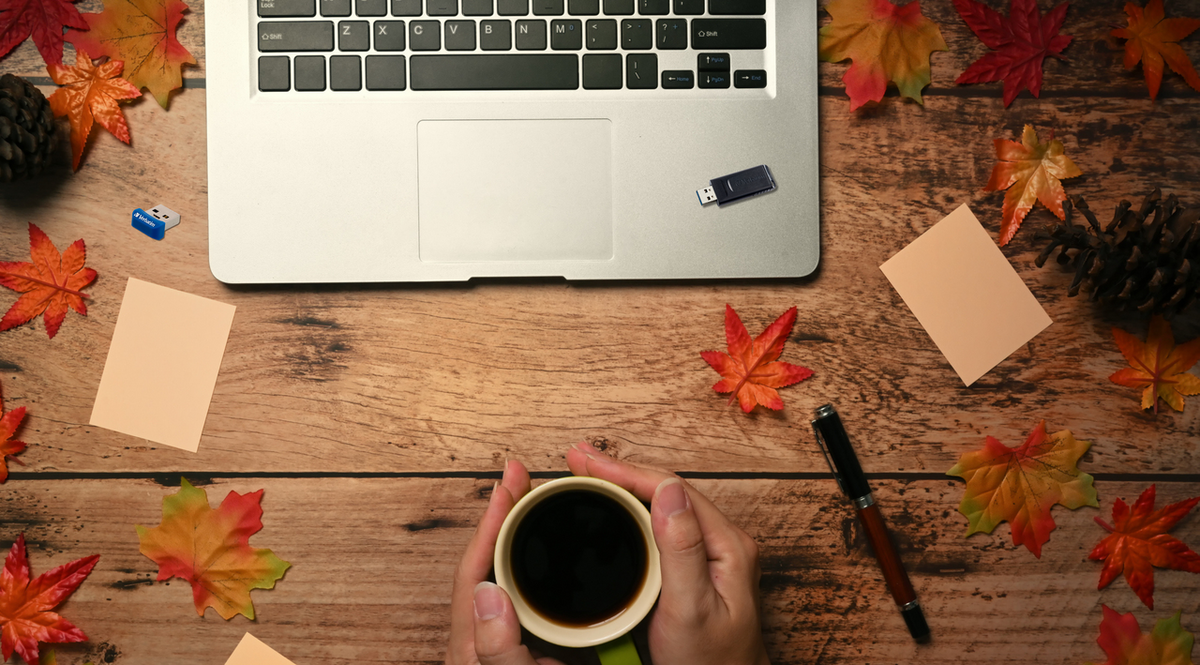 Autumn desk scene with Verbatim USB drives and laptop